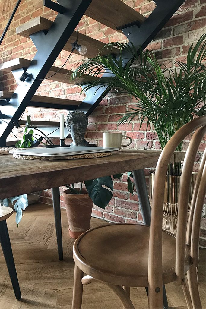 retro chairs, metal stairs in a loft style, loft interior, brick on the wall, lofts style, vintage accessories, large plants in the living room, metal lamps