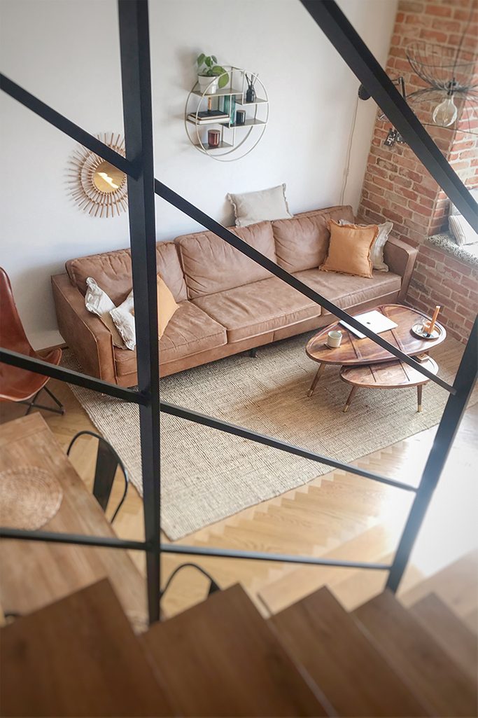 loft style apartment, brick in the apartment, vintage style, industrial decorative elements, metal wall shelf, retro sofa, coffee table set, wooden tables