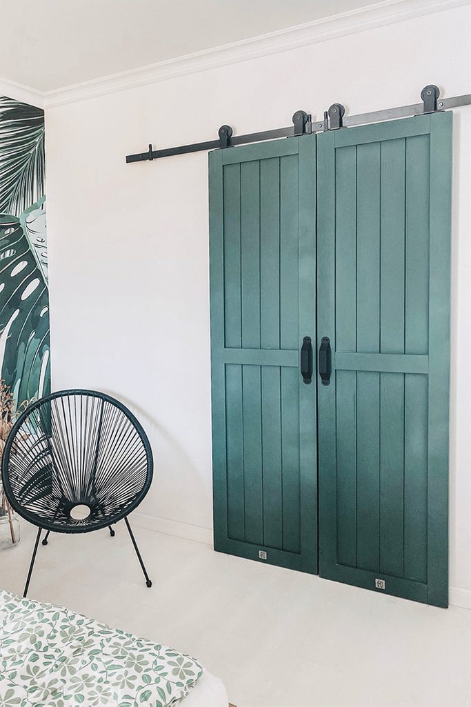 green doors, wardrobe door, sliding wardrobe door, black sliding door system, black openwork chair, solid wood door, white and green in the bedroom
