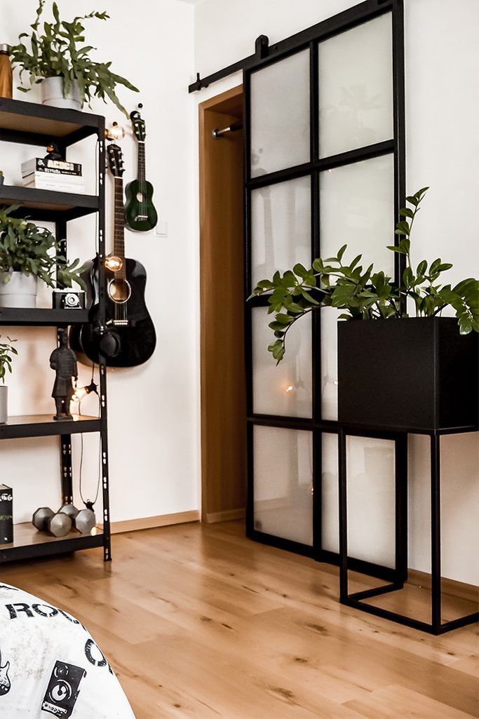 student room decoration, metal accessories in student room, loft style decoration, sliding door, metal stand for plant, wooden floor and glass door