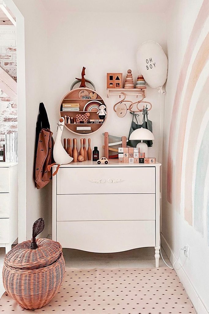 white bedroom design, children's corner in the parents' bedroom, wooden children toys, white chest of drawers in children's room, wicker storage basket